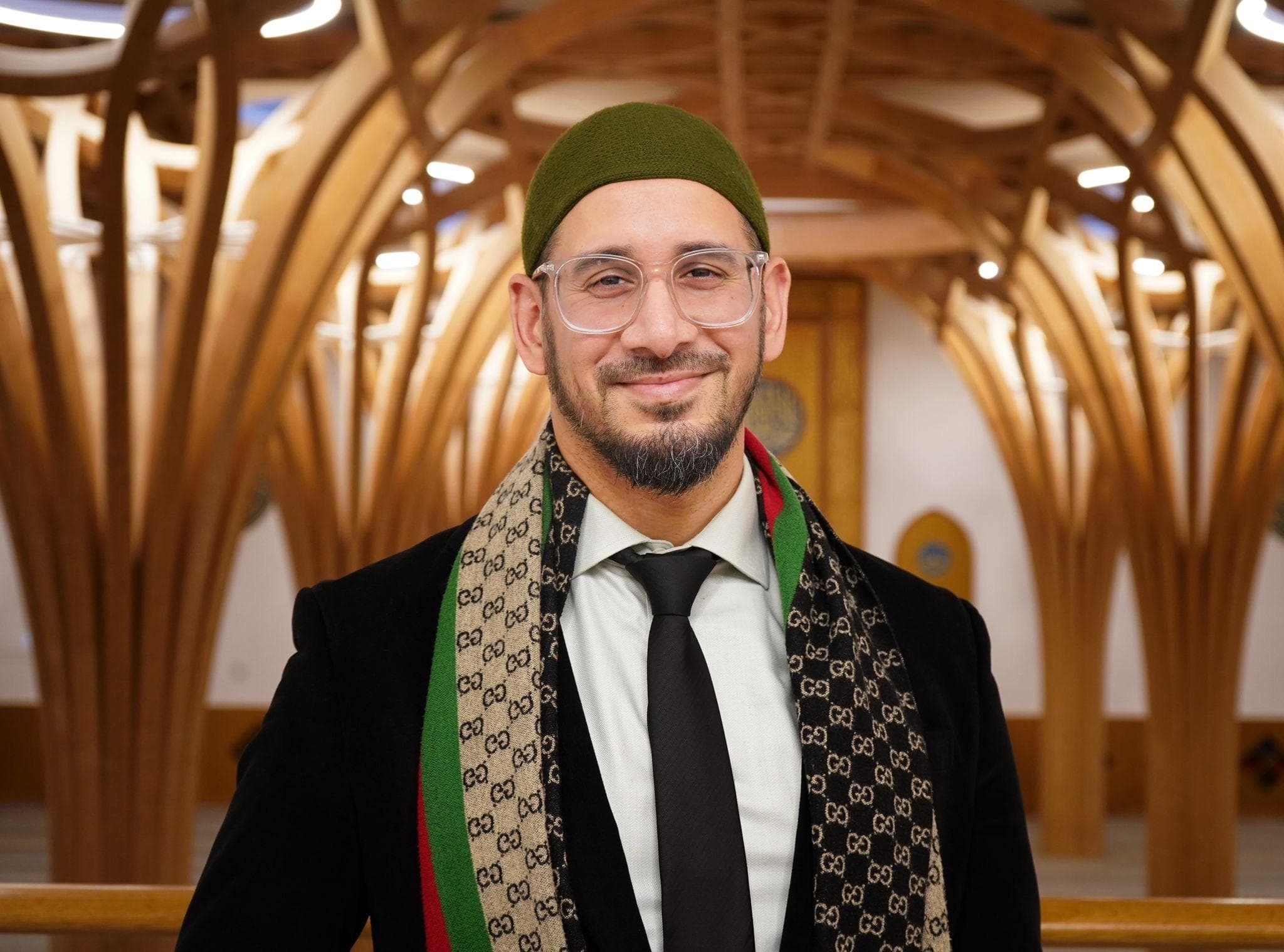 Professional portrait of Imam Zakarya Gangat in a modern wooden interior