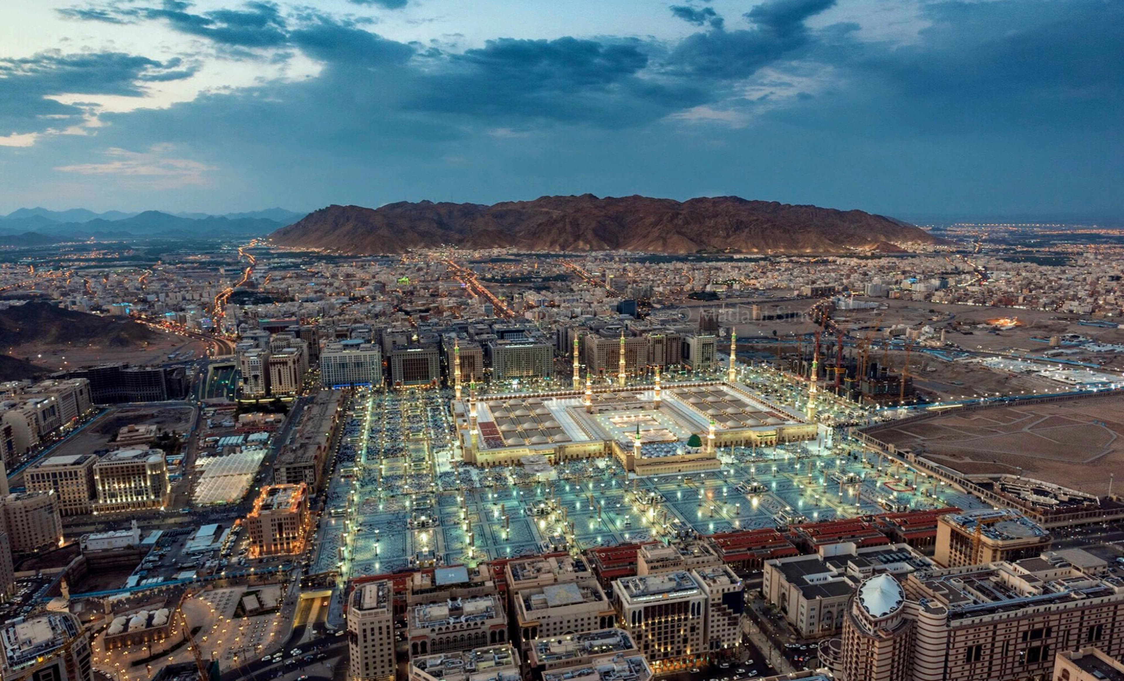 Aerial view of Madinah at twilight, Al-Masjid an-Nabawi and plazas illuminated