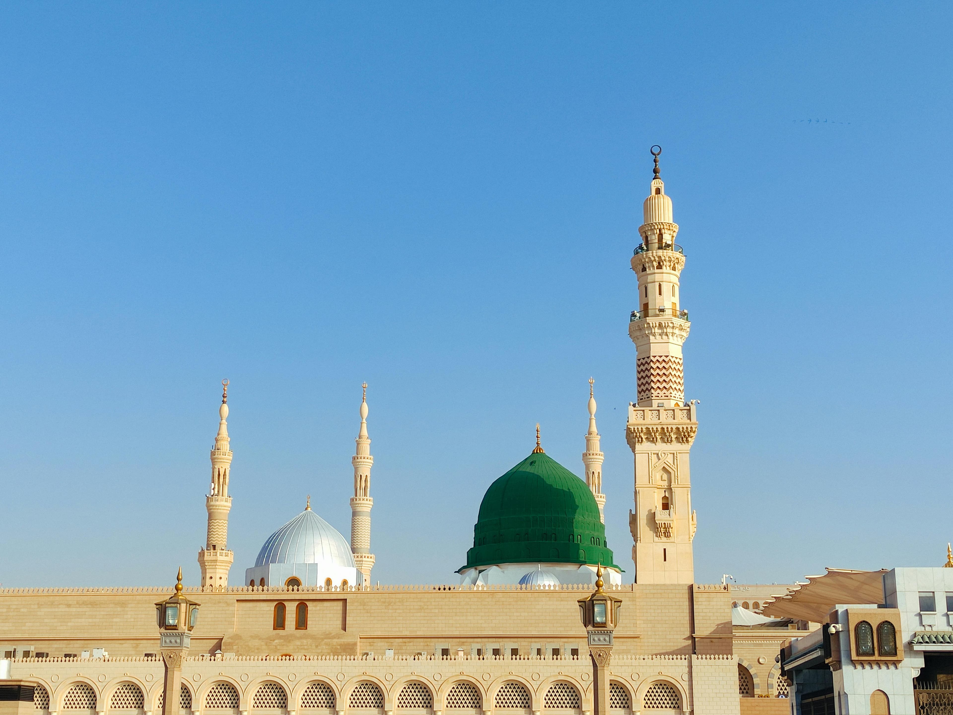 Al-Masjid an-Nabawi — green dome, silver dome, and minarets in daylight